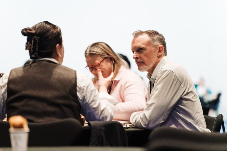 Photo of two Taituarā members having a discussion at a table