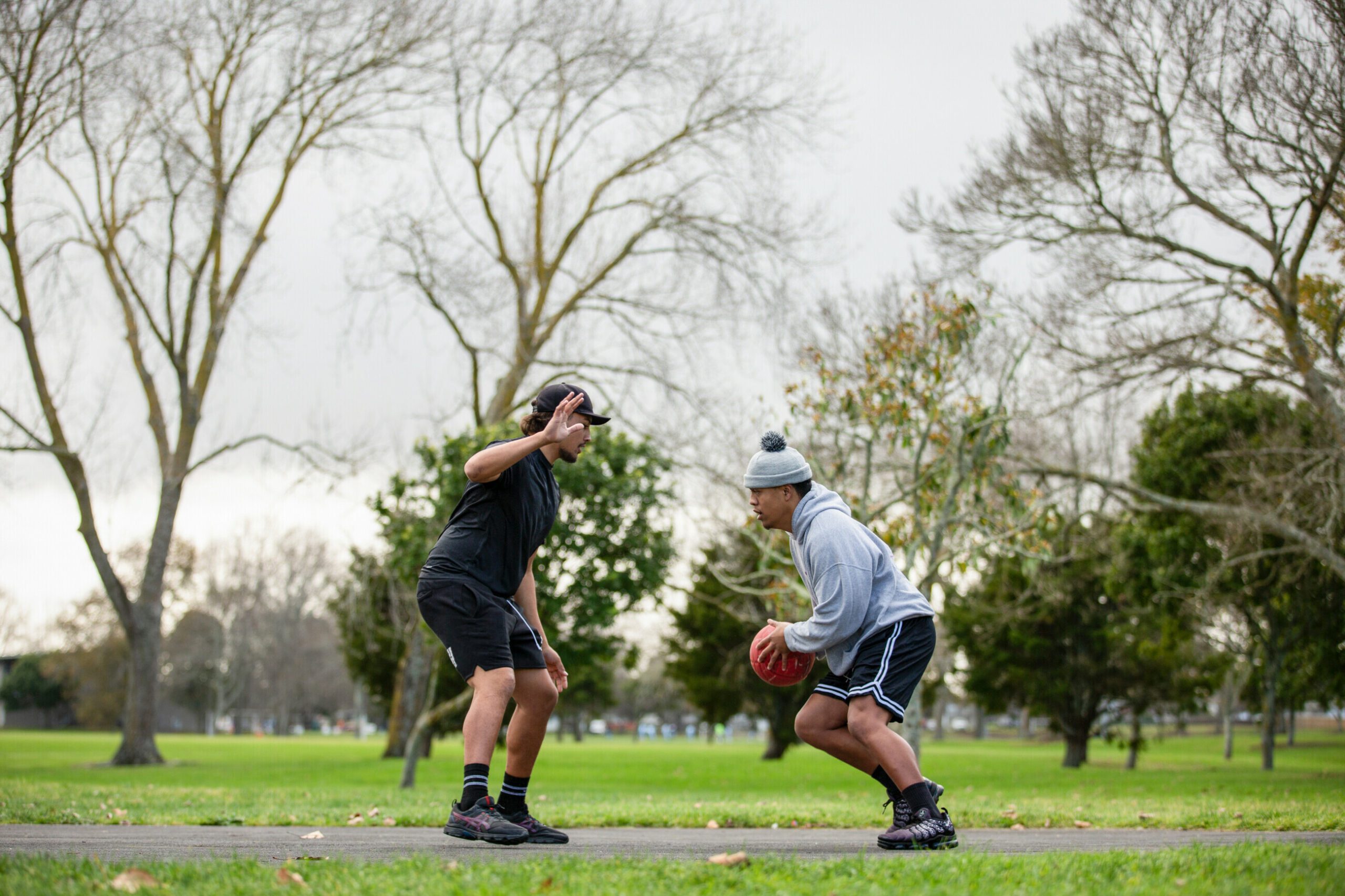 Photo of two basketballers playing on an outdoor court