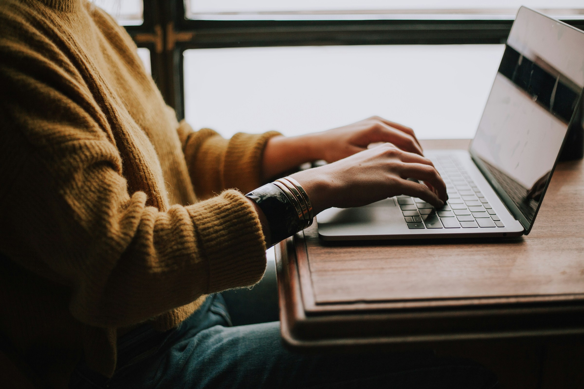 closeup view of someone using a laptop at a table