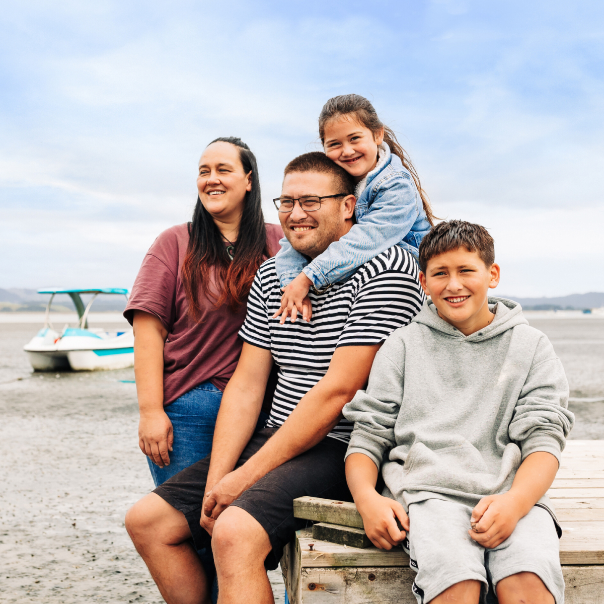 Photo of a family of four on a New Zealand beach