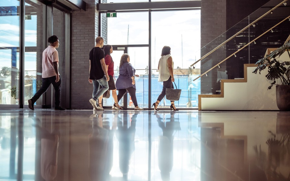 People walking towards a stairs in building entrance